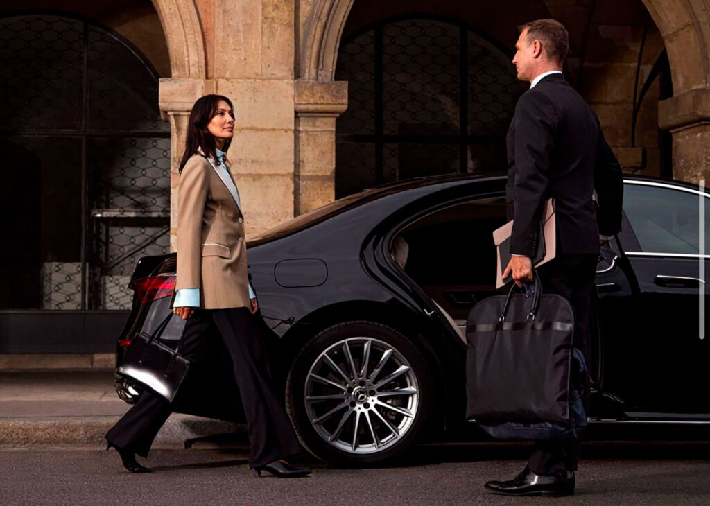 Professional chauffeur opening the door of a luxury black car in Houston